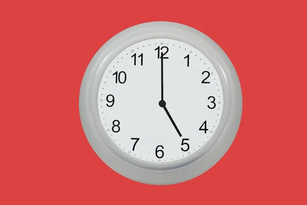 Настінний годинник ізольовано на червоному — стокове фото