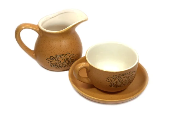 Taza de té chino marrón con platillo y lata de leche marrón aislada en blanco —  Fotos de Stock