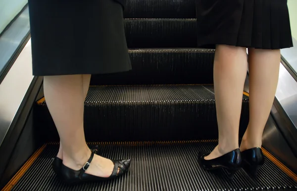 Två kvinnor står på rulltrappan Royaltyfria Stockbilder