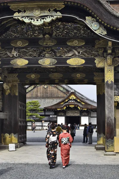 Женщины в кимоно входят в замок Нидзё — стоковое фото