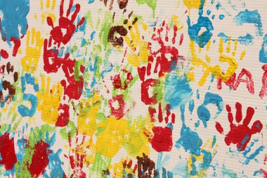Handprints in different colors in a mural. clipart