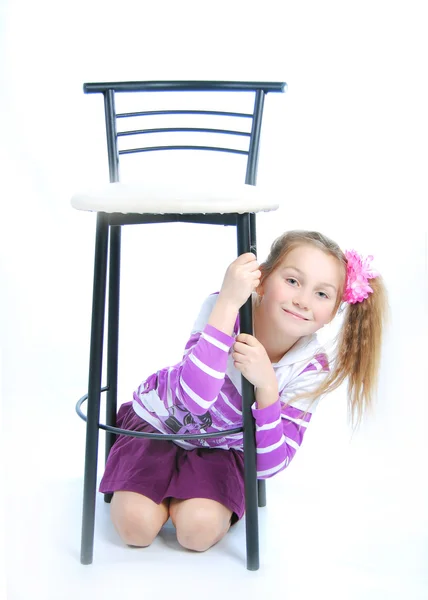 Het meisje onder een stoel — Stockfoto