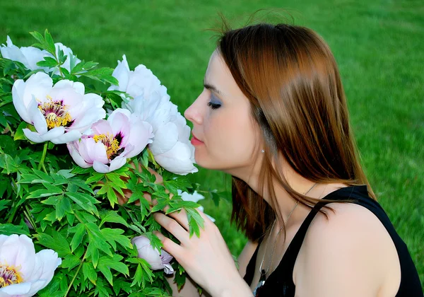 Ragazza sta annusando fiori Fotografia Stock