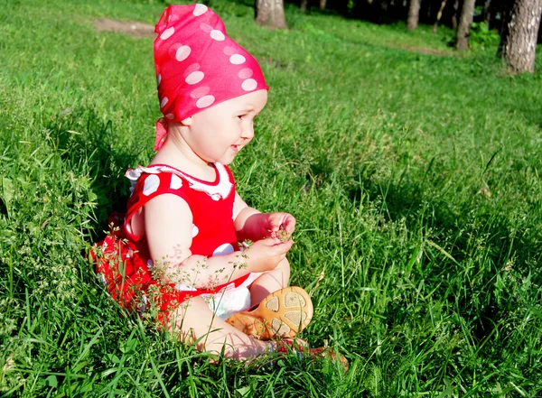 Baby sitzt auf dem Gras — Stockfoto