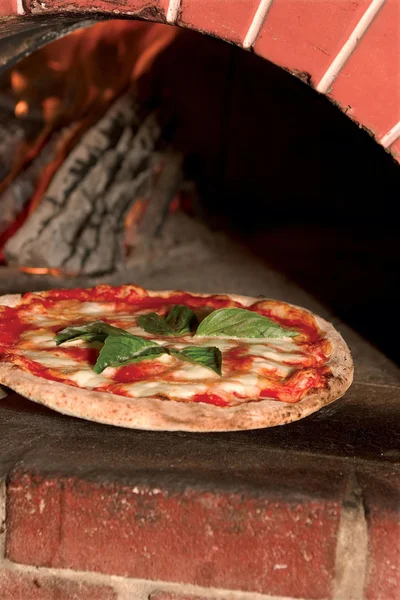 薪窯のレンガから新鮮なピザ ストック画像
