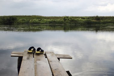 Sarı lastik terlikler Nehri yakınında ahşap köprü