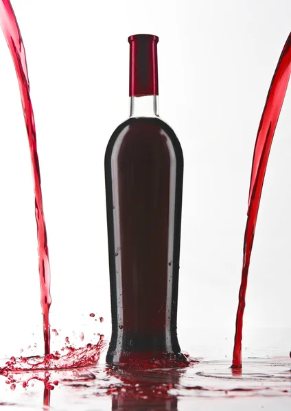 Botella de vino tinto con vino vertido — Foto de Stock