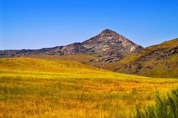 Pyramidal mountain in field — Stock Photo, Image