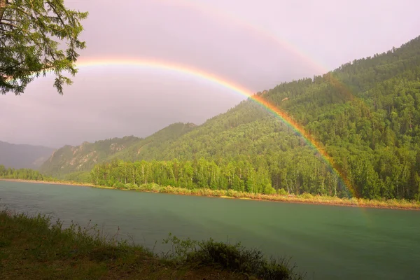 Regenboog boven de rivier — Stockfoto