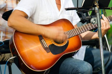 Adam akustik gitar çalıyor.