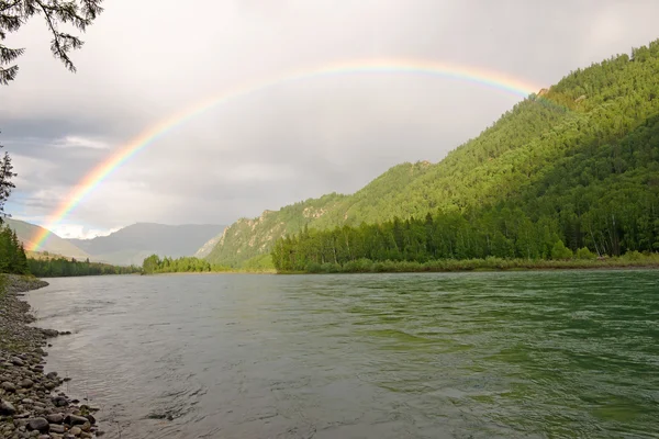 Regenboog boven de rivier — Stockfoto