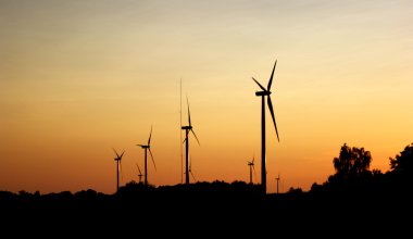 Wind turbines during sunset clipart