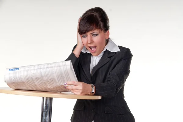 Een jonge zakenvrouw lezen nieuws papier en verrast — Stockfoto