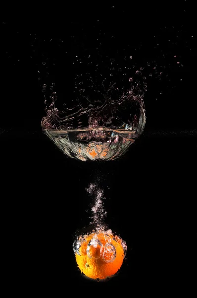 Stock image ORANGE FALLING INTO WATER