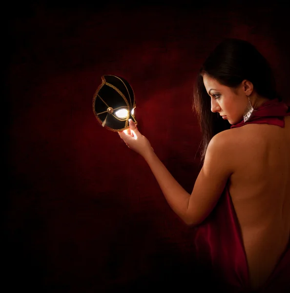 Beautiful woman looking at a magic mask — Stock Photo, Image