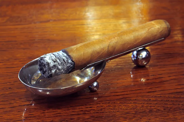 Сигара на підставці на дерев'яному фоні — стокове фото