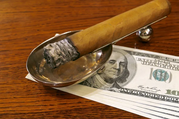 Cigar on a stand with money — Stock Photo, Image
