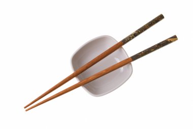 Wooden chopsticks on white saucer clipart