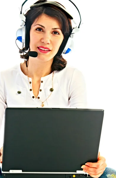 Vrouw in oortelefoon met laptop — Stockfoto