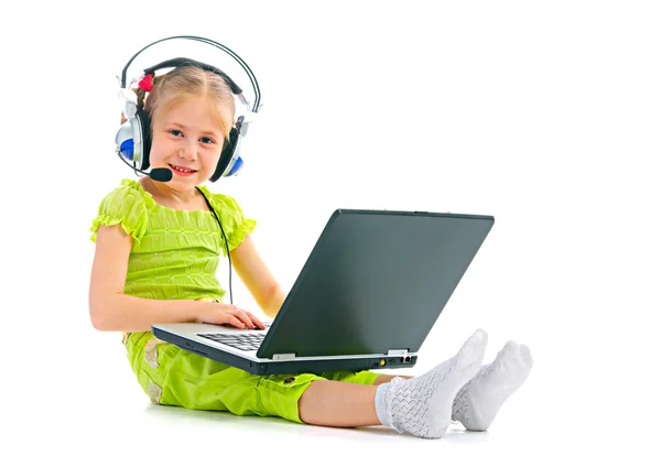 Ребёнок в наушниках с ноутбуком — стоковое фото