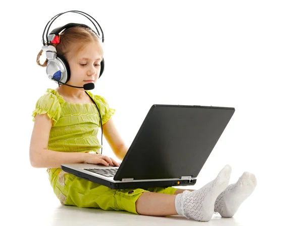 Kulaklık dizüstü bilgisayar ile küçük kız — Stok fotoğraf