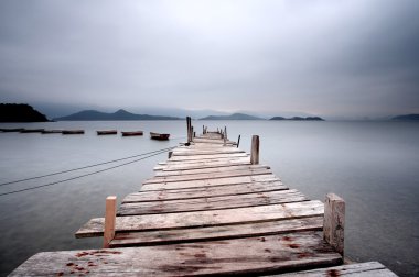 Looking over a pier and a boat clipart