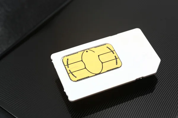 stock image Sim card on a black metal background