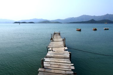 Looking over a pier and a boat clipart