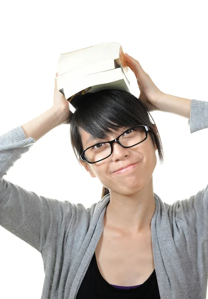Flicka med böcker på huvud — Stockfoto