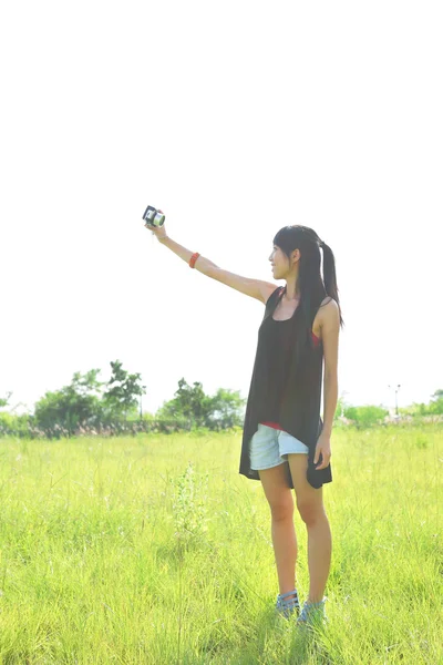 Woman taking a photo of herself outdoor in soft color tone — Stock Photo, Image