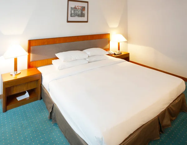 Двуспальная кровать в комфортабельном номере отеля — стоковое фото