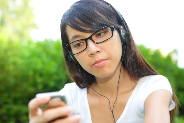 Girl listen to music with headphones, chinese — Stock Photo, Image