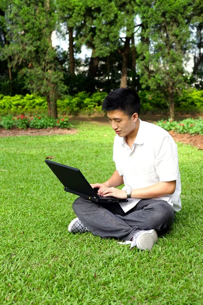 Asian man using computer outdoor — Stock Photo, Image