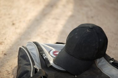 Ball cap on a bag clipart