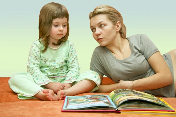 Moeder leest een sprookje dat werd naar het kind Stockfoto