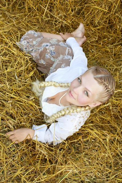 The girl with plaits on straw — Stock Photo, Image