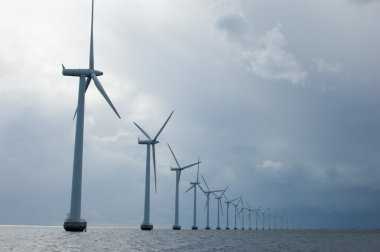 Windmills in a row on cloudy weather, close clipart