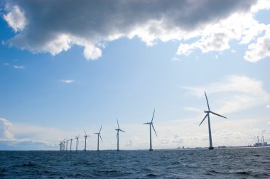 Windmills in a row on sunny weather, back shot clipart