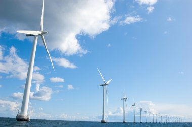 Windmills lined up in the sea, close clipart