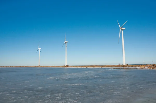 Three windmills near frozen lake — Stock Photo, Image