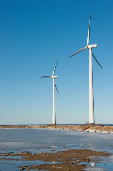 stock image Two windmills near seaside with reflection in th