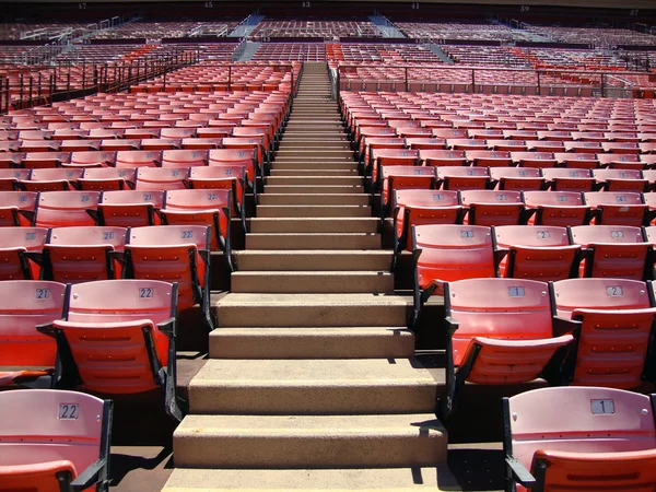 Reihen leerer orangefarbener Stadionsitze gehen nach oben — Stockfoto