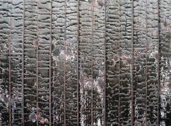 Burned painted red wood on the side on a old rail car — Stock Photo, Image