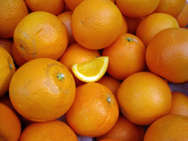 Naranjas orgánicas con una pequeña rebanada de naranja en el medio — Foto de Stock