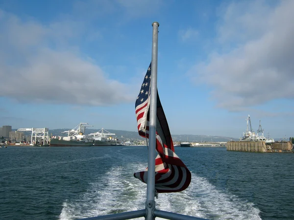 USA Flag waves on the back of a ferry as it sails out of Oakland — Stock Photo, Image