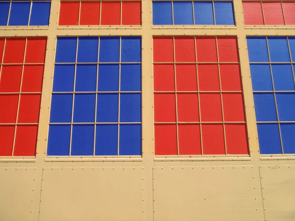 Vermelho e azul sólidas janelas coloridas em uma parede de aço moda antiga — Fotografia de Stock