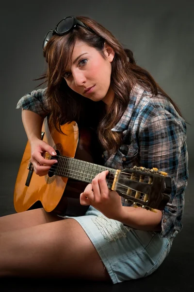 Юная девушка играет на гитаре — стоковое фото