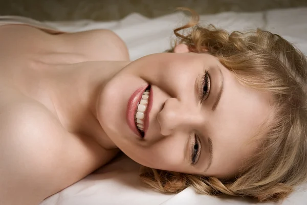 Dziewczyna w łóżku śmiejąc się — Zdjęcie stockowe