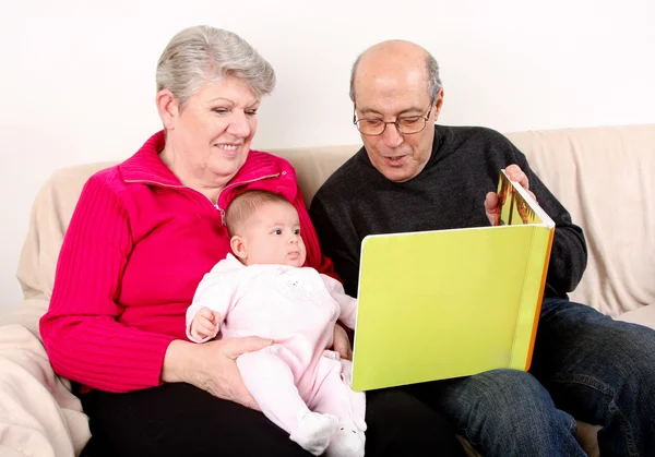 Familie liest Buch für Baby — Stockfoto