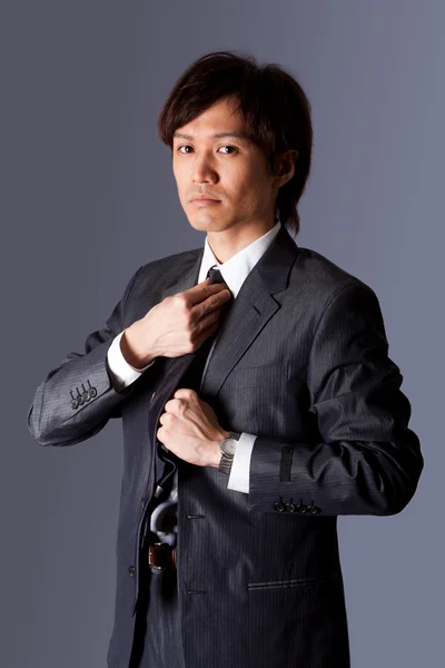 Erfolgreiche asiatische Geschäftsmann Fixierung Krawatte — Stockfoto